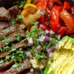High protein steak fajita bowl with sliced skirt steak, cauliflower rice, and roasted bell peppers in white bowl