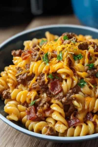 Loaded bacon cheeseburger pasta in large skillet with melted cheese and crispy bacon