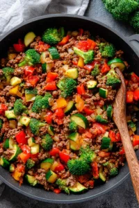 Meal prep ground beef veggie skillet with colorful vegetables in cast iron pan