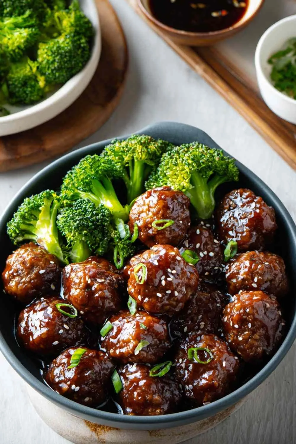 Sticky Mongolian meatballs and broccoli served over white rice with sesame seeds and green onions