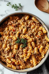 Stovetop creamy ground beef pasta in a large skillet with melted parmesan cheese and herbs