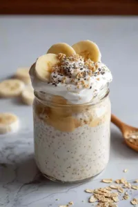 Spoon lifting creamy banana cream pie overnight oats from bowl