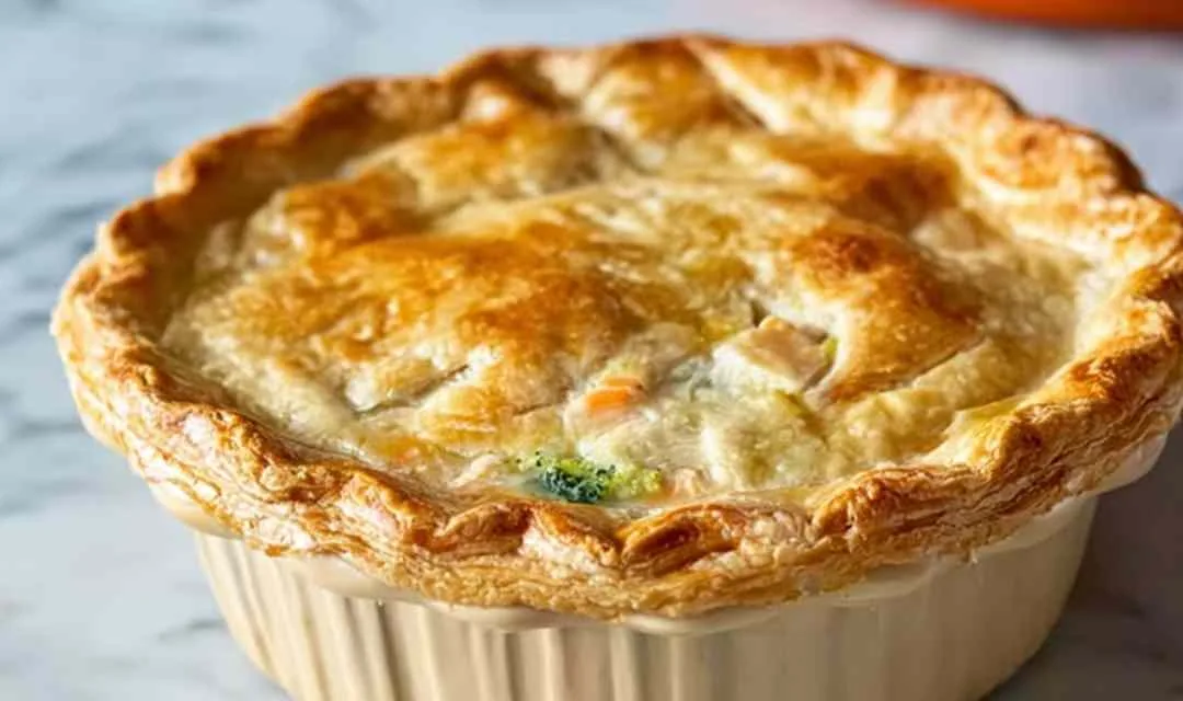 Golden broccoli cheddar chicken pot pie with flaky crust on cooling rack
