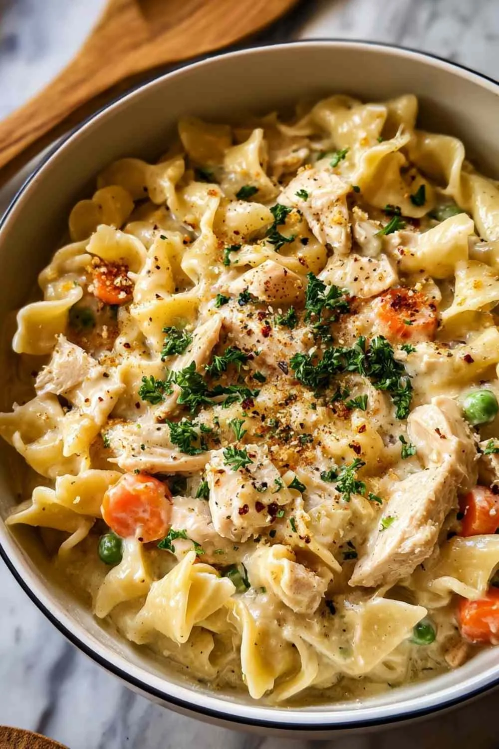 Close up of creamy chicken pot pie pasta with vegetables and herbs