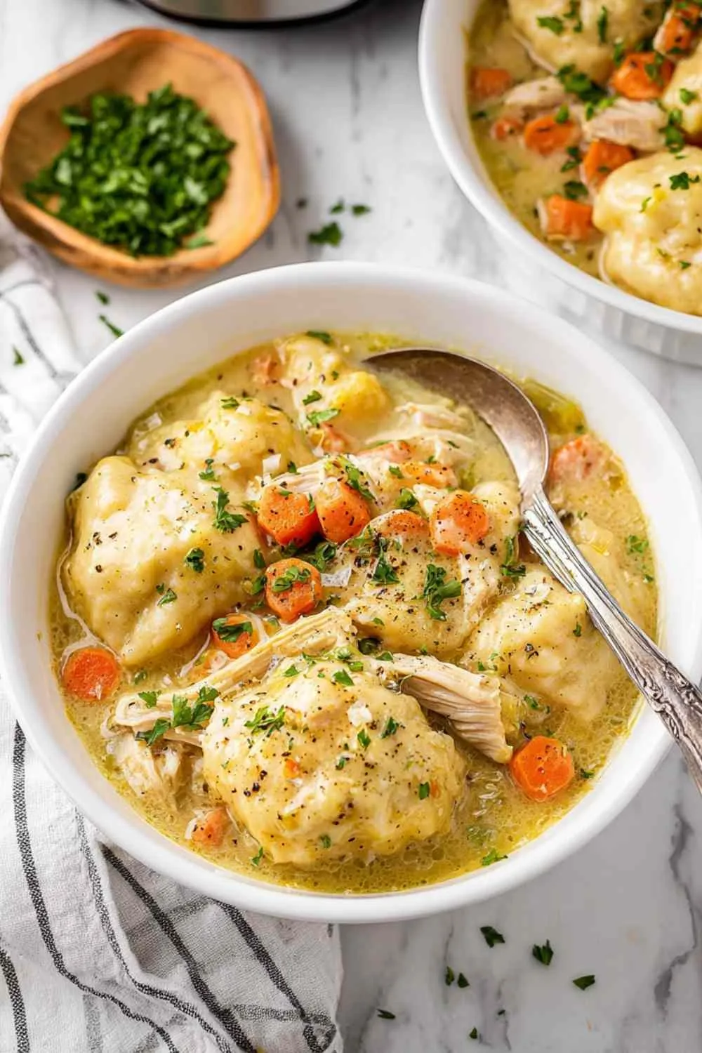 Close up of fluffy biscuit dumplings in creamy chicken and vegetable sauce