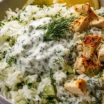 Close up of Dump and Bake Chicken Tzatziki Rice showing creamy sauce and tender chicken