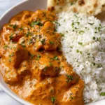 Creamy butter chicken recipe served in skillet with rice and naan bread