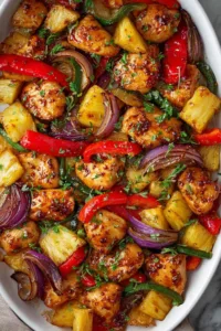 Plated Hawaiian chicken sheet pan meal served over rice with fresh herbs