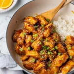 Fresh orange juice, chicken breast, and ingredients for healthy orange chicken recipe