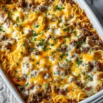 Layered beef noodle casserole served on plate showing creamy noodles and meat sauce