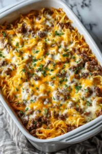 Layered beef noodle casserole served on plate showing creamy noodles and meat sauce