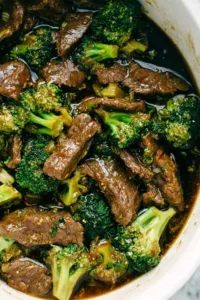 Slow cooker beef and broccoli served over white rice with sesame seeds and green onions