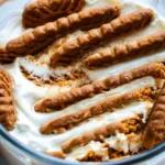 2-ingredient yogurt cheesecake with Biscoff cookies in a glass bowl drizzled with honey