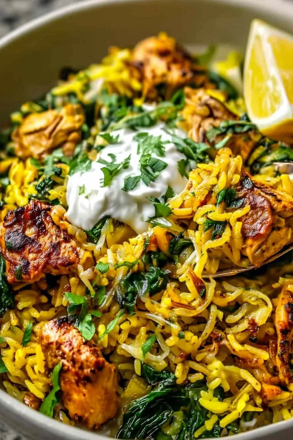 anti inflammatory turmeric chicken and rice in a bowl with fresh spinach and lemon