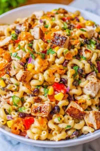 A colorful bowl of BBQ Chicken Pasta Salad with juicy chicken, black beans, and bell peppers.