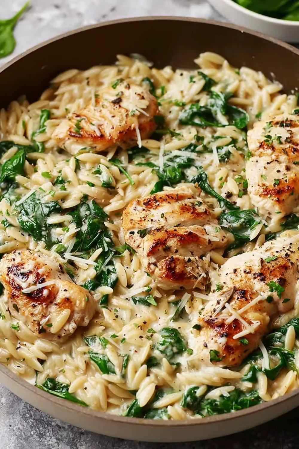 Creamy Boursin orzo chicken with spinach served in a skillet