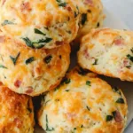 breakfast protein biscuits on parchment lined baking tray with melted cheddar topping