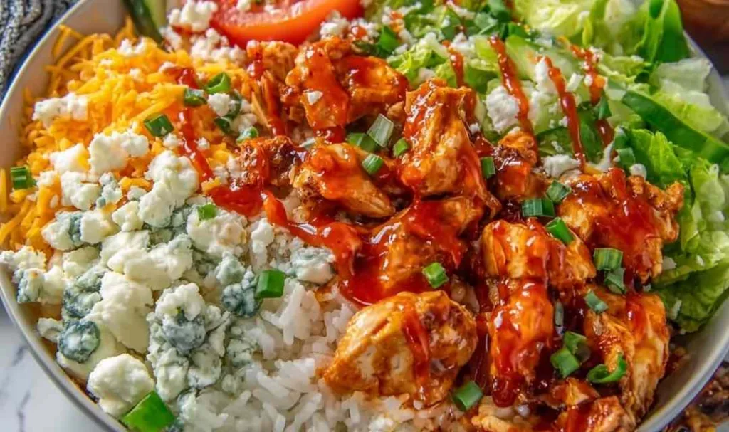 Buffalo chicken protein bowl with rice, tomatoes, and ranch dressing
