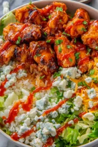 Buffalo chicken protein bowl with rice, tomatoes, and ranch dressing
