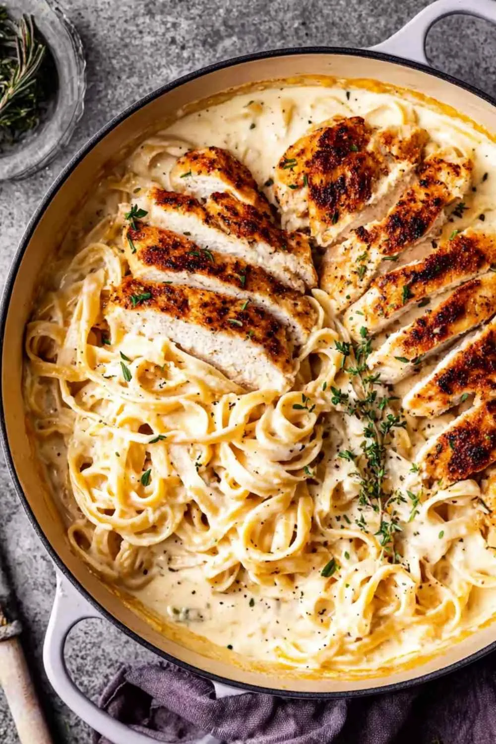 Creamy chicken Alfredo with fettuccine and fresh parsley on a white plate