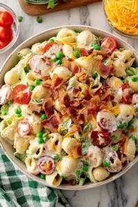 Creamy Bacon Ranch Pasta Salad in a large white bowl with crispy bacon and fresh herbs