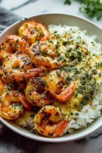Creamy herb rice with garlic butter shrimp bowl served in a white bowl