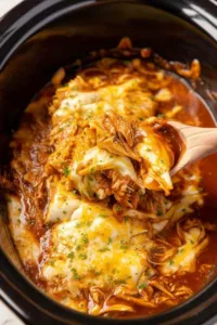 Crockpot chicken enchiladas in slow cooker topped with melted colby jack cheese