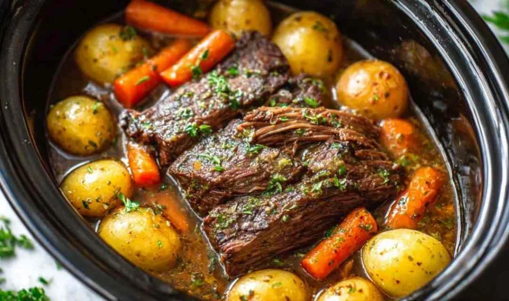 garlic herb crockpot beef pot roast in slow cooker with carrots and potatoes