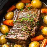 garlic herb crockpot beef pot roast in slow cooker with carrots and potatoes