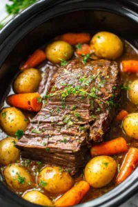 garlic herb crockpot beef pot roast in slow cooker with carrots and potatoes