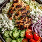 Greek Chicken Bowls with tzatziki sauce on a white table