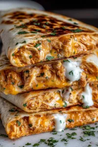 High Protein Chicken Ranch Quesadilla sliced into wedges on a wooden board showing melted cheese and crispy tortilla.