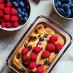 High Protein Pancake Bowl with fresh berries in a glass ramekin on a marble counter.