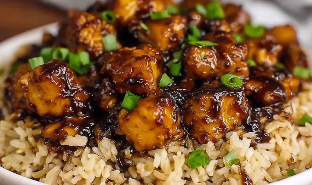Honey BBQ Chicken Rice Recipe served in a cast iron skillet topped with green onions.