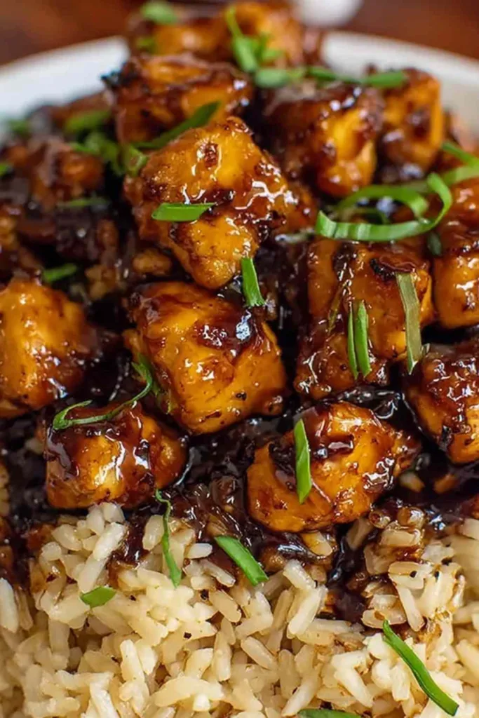 Honey BBQ Chicken Rice Recipe served in a cast iron skillet topped with green onions.