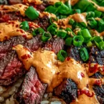 Korean BBQ steak rice bowls with spicy cream sauce on a white table