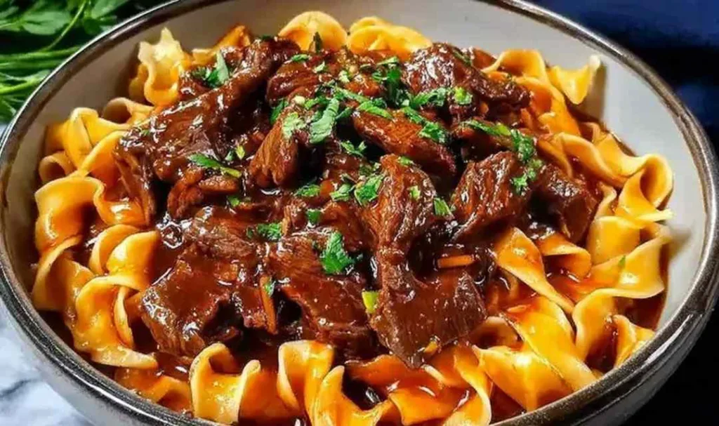 Korean beef noodles in a deep bowl with green onions and sesame seeds