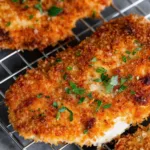 Golden brown Panko Crusted Chicken Breasts on a white plate