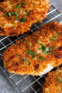 Golden brown Panko Crusted Chicken Breasts on a white plate