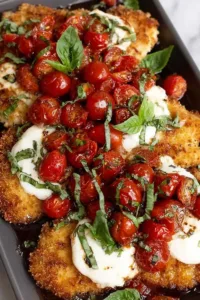 Golden crispy Parmesan Basil Chicken Cutlets on a white plate.