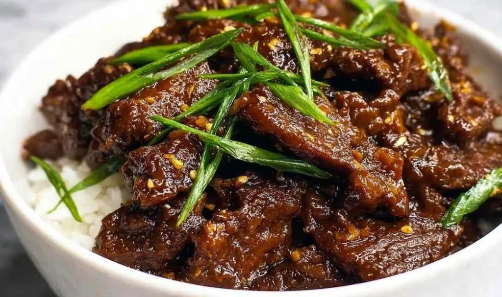 Slow cooker Mongolian beef served over steamed white rice topped with green onions