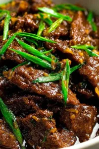 Slow cooker Mongolian beef served over steamed white rice topped with green onions