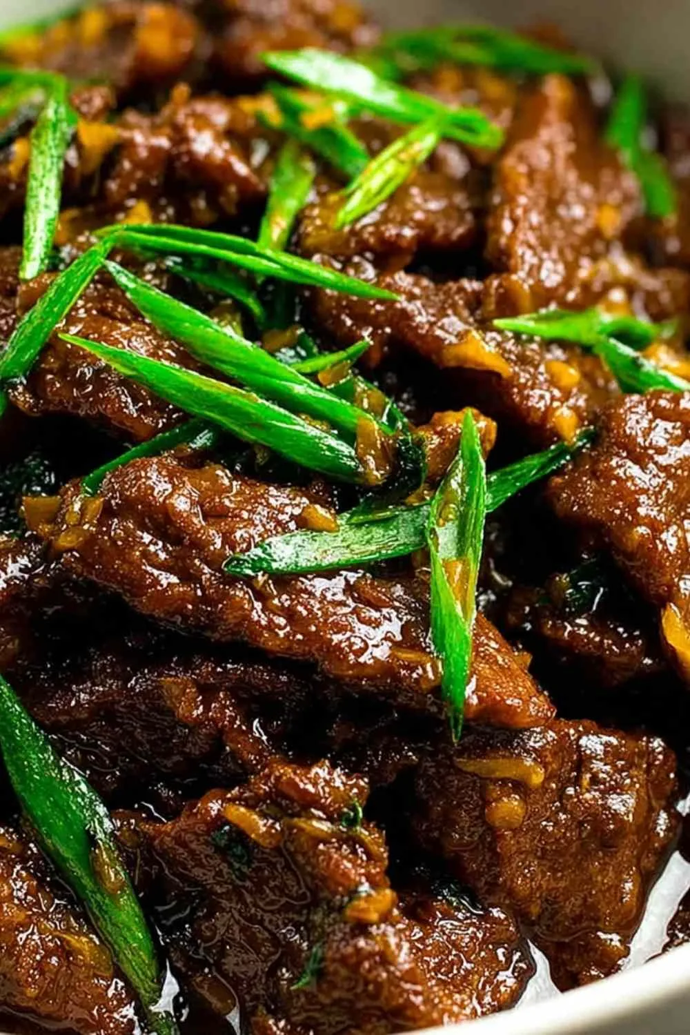 Slow cooker Mongolian beef served over steamed white rice topped with green onions