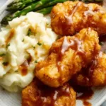 Smothered chicken breasts in creamy sauce served in a skillet with fresh parsley
