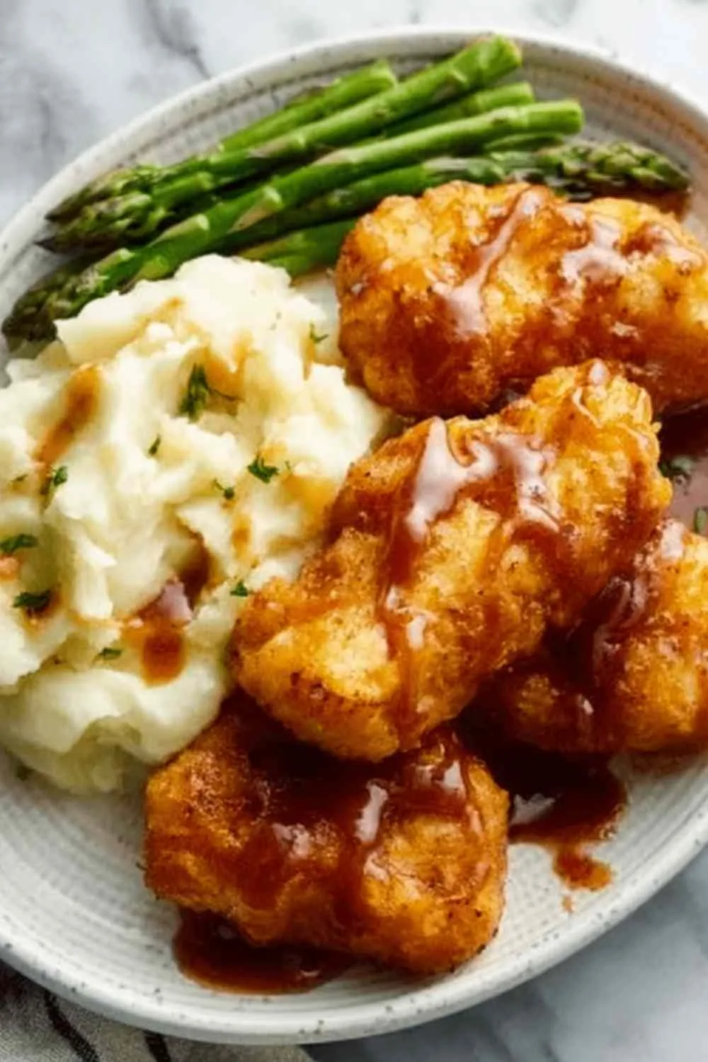 Smothered chicken breasts in creamy sauce served in a skillet with fresh parsley