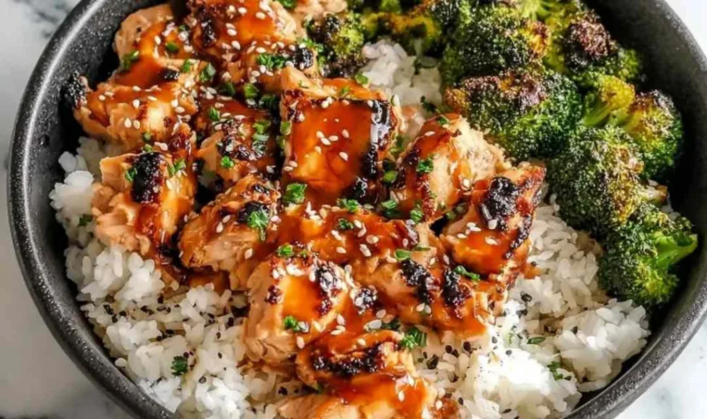 Sticky Chicken Rice Bowls in white bowl with sesame seeds and green onions