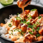 Sweet Chili Chicken Bowl with Coconut Lime Drizzle Magic in a white bowl on a wooden table.