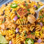 Zesty chicken enchilada pasta salad in a large white bowl topped with fresh cilantro and sliced jalapeno
