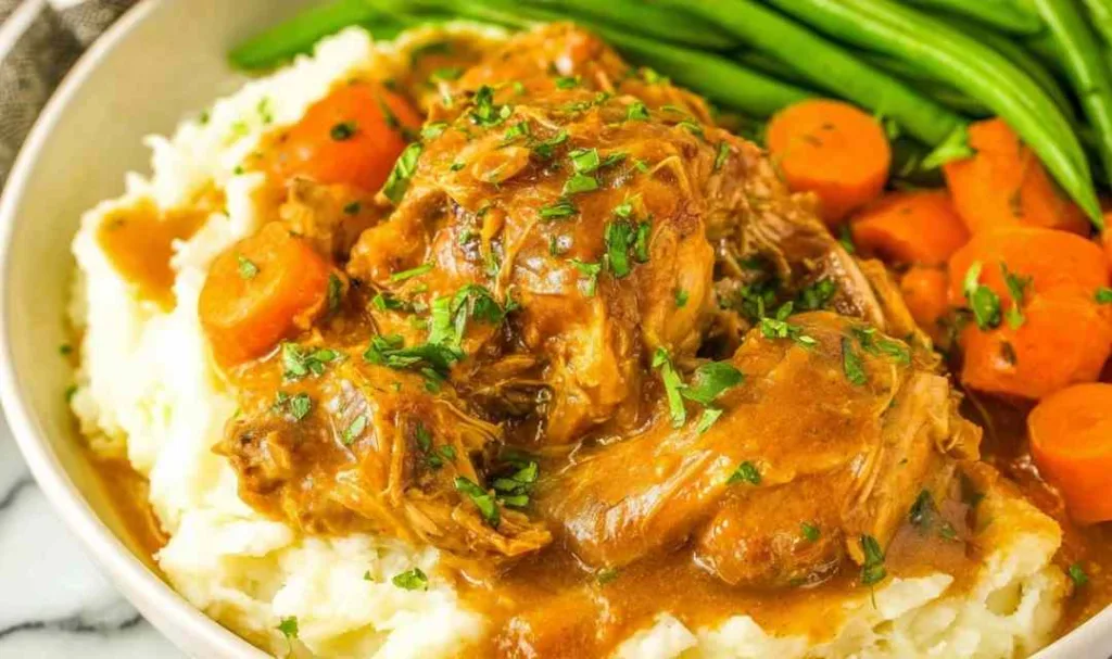 Crockpot chicken pot roast with carrots and celery in slow cooker