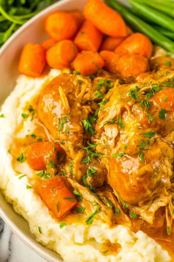Crockpot chicken pot roast with carrots and celery in slow cooker